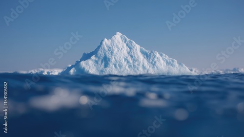 A massive, snow-covered iceberg floating in the ocean with other icebergs around it