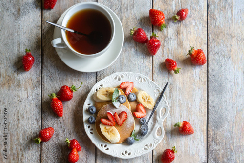 Light breakfast, pancakes with fruits and berries on the table.