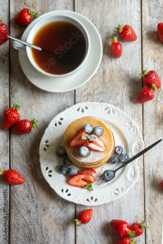 Light breakfast, pancakes with fruits and berries on the table.