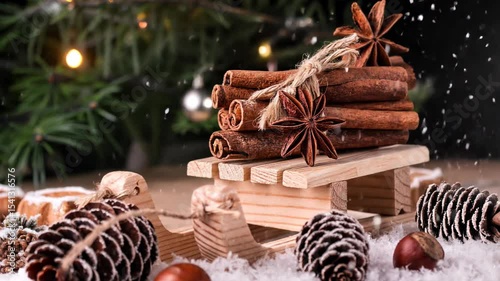 Christmas card with wooden sled with heap of cinnamon over old wooden background with falling snow.  Merry Christmas and New Year concept