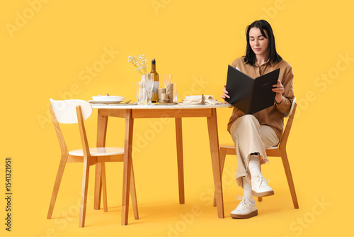 Young woman with menu at re...