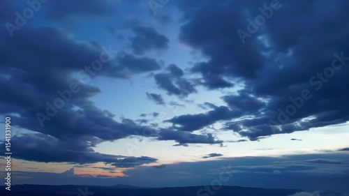 Ominous storm clouds gather dramatically above a darkening horizon casting a blue glow