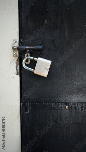 Silver Padlock on Black Iron Gate – Security and Protection Concept