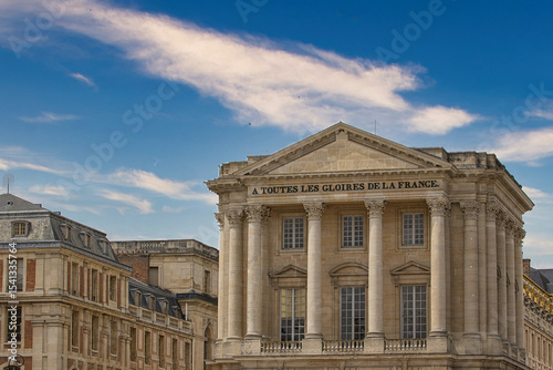 Architectural Exterior of Building with Columns and Blue Sky at Versailles Gardens, Paris.