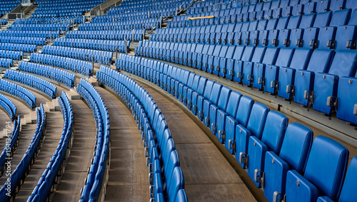 Rows of empty blue stadium seats in a curved arrangement, creating a sense of anticipation and vastness in the venue. AI generated.

