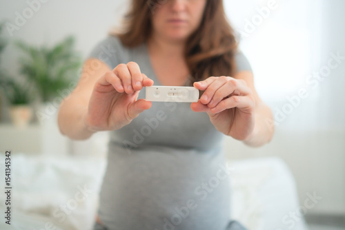 Expecting mother nervously viewing polymerase chain reaction results. Crucial infection screening for maternal and baby's health.