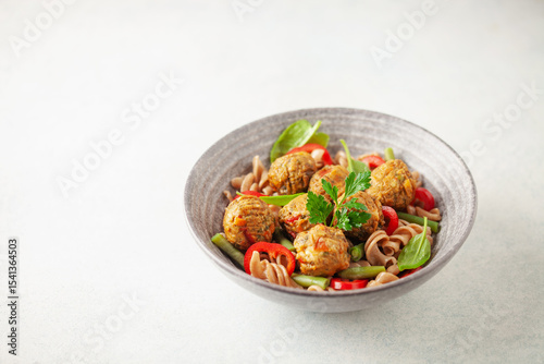 Vegan food. Vegetable meatballs and buckwheat pasta with vegetables in a bowl on the table.