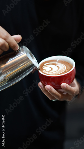 Barista Hand Pouring Latte Art into Coffee Cup – Close-up Potrait Coffee Making Process