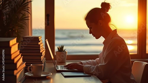 Focused woman typing on laptop near ocean sunset
