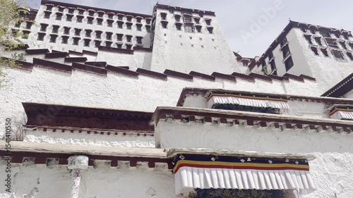 Establishing upward angle of Potala Palace in Lhasa with mountain backdrop under cloudy sky