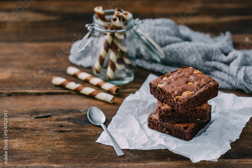 Fotografía Delicious Brownies with Nuts and Chocolate Rolls on Rustic Background