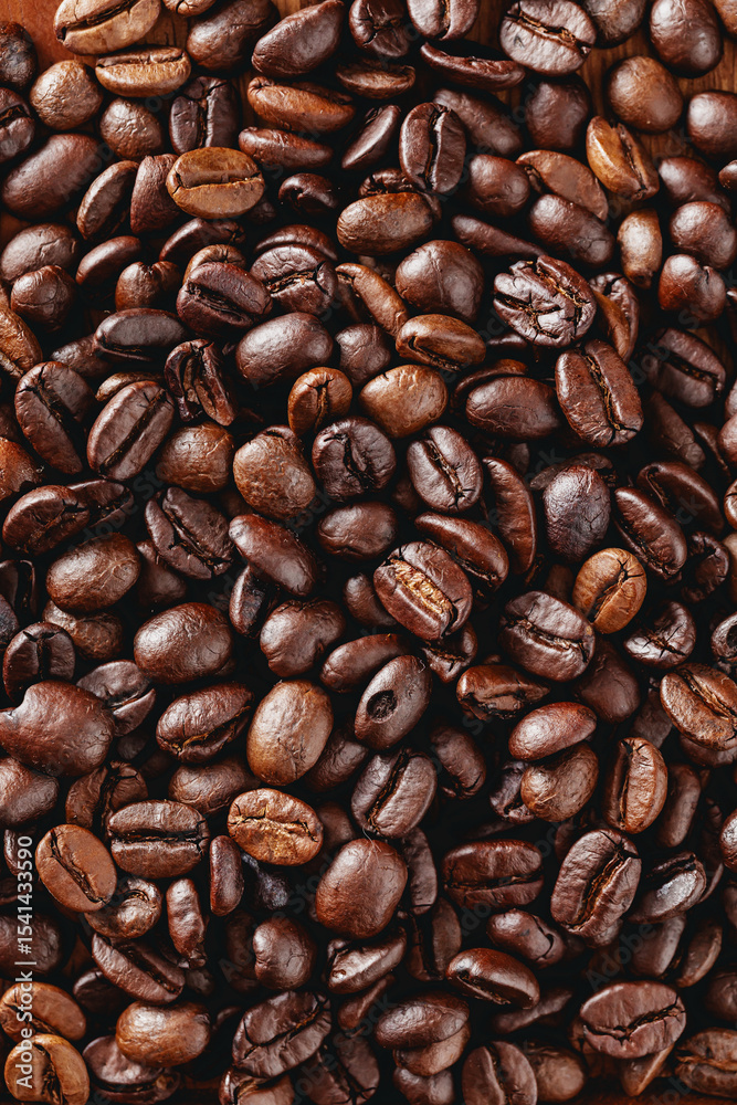 Fototapeta premium Dark Roasted Coffee Beans Spread Evenly on a Wooden Table Surface