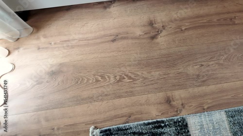 Natural wood laminate parquet floor. Room with floating laminate in new apartmen. Cozy home interior, modern design