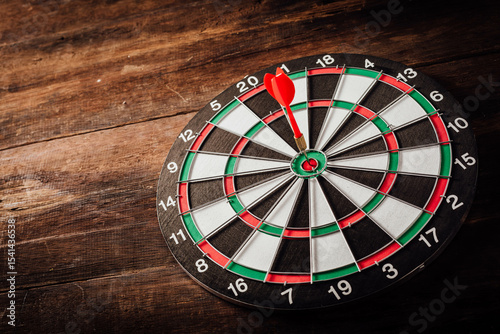 Precision Throw with Red Dart on Classic Dartboard on Wooden Surface
