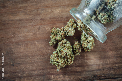 Freshly Harvested Cannabis Buds Spilling from a Glass Jar