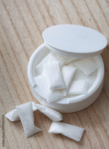 white container of nicotine pouches on wooden table