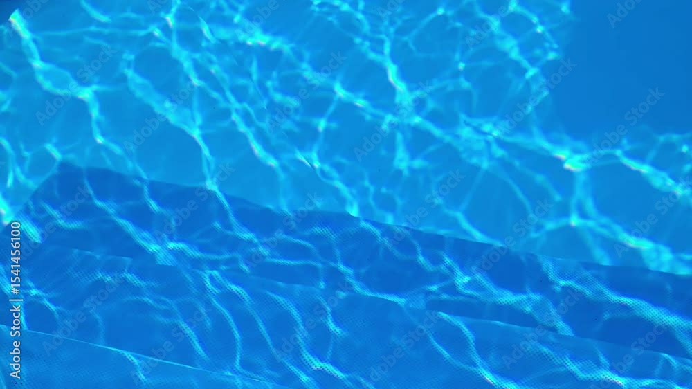 Bright sunlight reflecting on crystal clear swimming pool surface, creating mesmerizing turquoise patterns highlighting peaceful summer leisure and relaxation