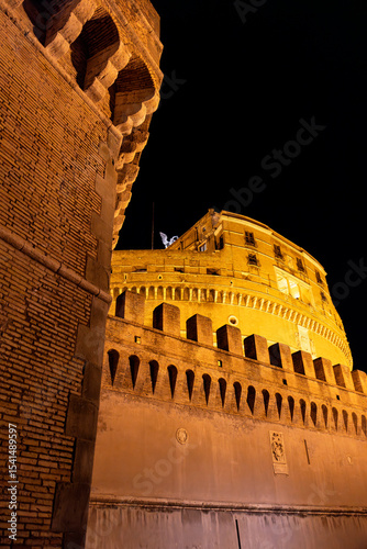 Night view of Castel Sant’Angelo in Rome, beautifully illuminated and surrounded by evening visitors