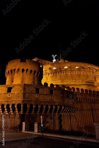 Night view of Castel Sant’Angelo in Rome, beautifully illuminated and surrounded by evening visitors