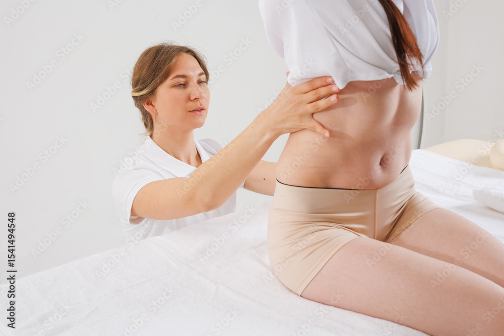 Obraz premium Specialist Examining Patient’s Lower Spine for Scoliosis, Curvature, Hernia or Postural Deformities