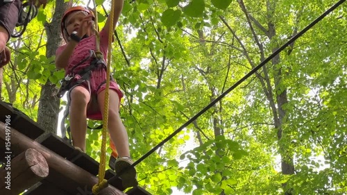 a child walks along an obstacle course in a rope park