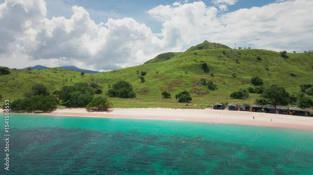 A captivating view of a stunning tropical beach with pink-hued sand, crystal-clear turquoise water, and towering green hills under a bright blue sky, in Komodo National Park, Flores. A captivating view of a stunning tropical beach with pink-hued sand, crystal-clear turquoise water, and towering green hills under a bright blue sky, in Komodo National Park, Flores.