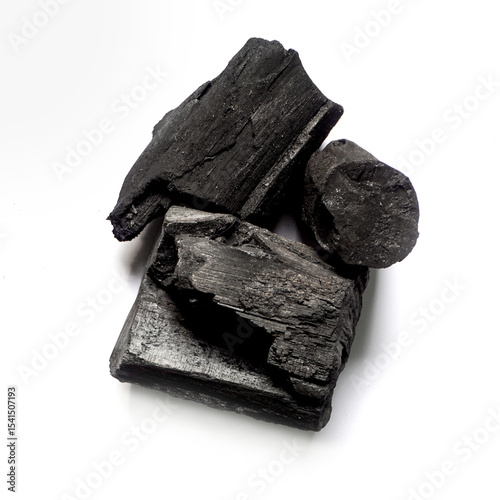 Black charcoal lumps placed on a white background.