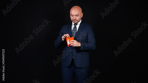 Elegant businessman enjoying french fries on black background