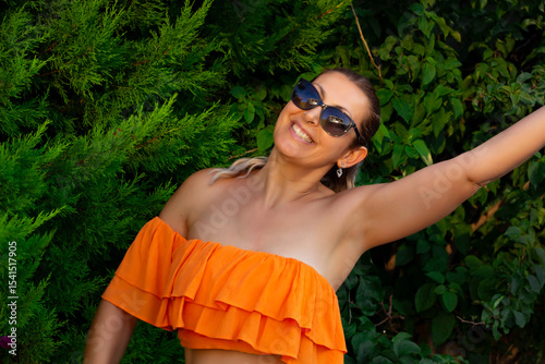portrait of a beautiful young woman smiling at camera  in the garden