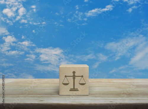 Law flat icon on wood block cube on wooden table over blue sky with white clouds, Business legal service concept
