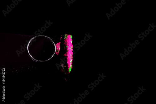 Side view of a soda can lid with water droplets, dark background, close-up macro shot.

