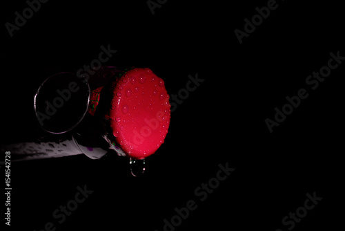 Macro photo of a green soda can lid with water droplets, dark background, high contrast close-up.

