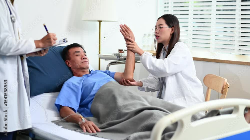 Medical professional helps patient with arm movement therapy during bedside exam. Great for rehabilitation, recovery, hospital care