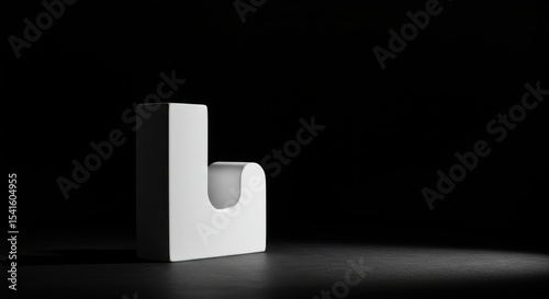 Stark white hook basks in spotlight poised against a backdrop of inky black