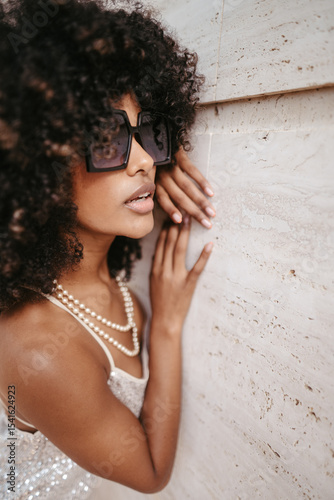 Portrait of a woman with afro hair and sunglasses smiling and happy - Modern fashion and style concept.