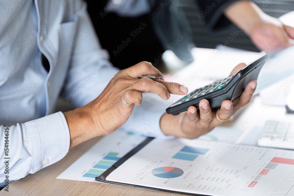 Fototapeta premium Financial Calculation and Data Management. Professional using a calculator for financial analysis.