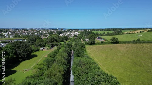Churston, South Devon, England: DRONE VIEWS: A steam train on route from Kingswear to Paignton; the sea of Torbay is in the distance. South Devon is a popular UK holiday destination (Clip 1 of 2).
