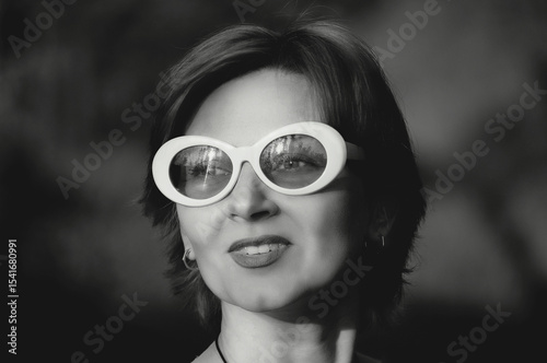 Black and white retro photo of a beautiful girl with glasses