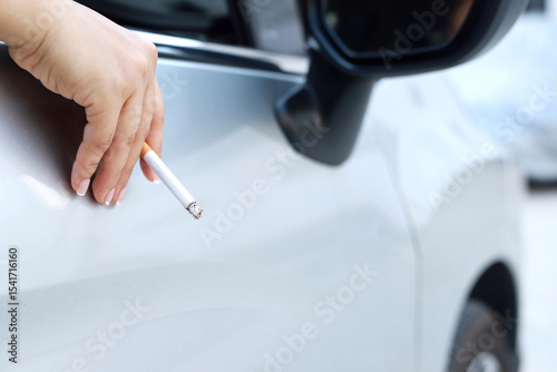 close up woman hand hold smoking a cigarette in car while driving travel. healthy lifestyle. or No smoking campaign Concept.