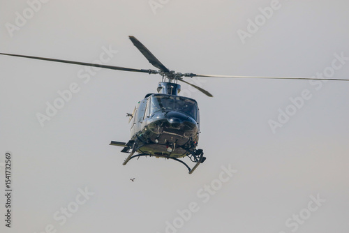 Black colour bell 412 helicopter in hover over an air field and ready for departure