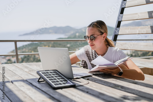 digital nomad woman working remotely from a cozy kitchen during breakfast. Remote work, sustainability, wellness, Gen Z, conscious living, home office and online freelancing