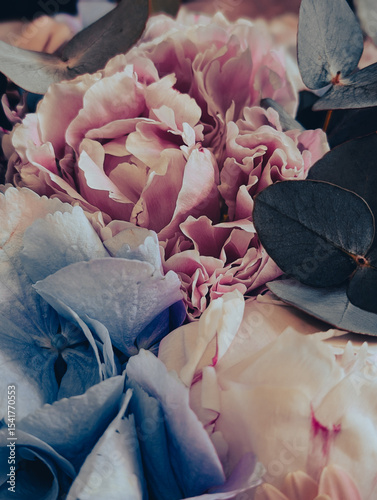 Vertical floral background with a soft pink rose and pastel blue and white hydrangeas