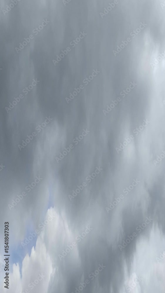 Un cielo de azul con varias nubes de color blanco y gris con un movimiento lento. Video vertical
