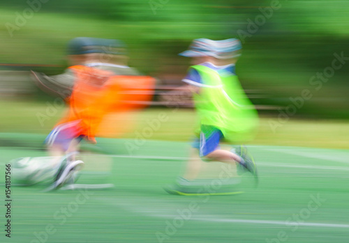 little four -year-old boys plays football at a sports school .Blur.