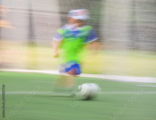 little four -year-old boys plays football at a sports school .Blur.