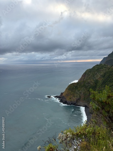 Rugged coastline of Madeira Island in Portugal and ocean waves. A picturesque green shore with impressive views of jagged rocks.