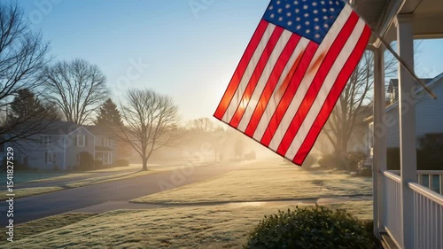 American flag waving in morning light over frosty neighborhood street  