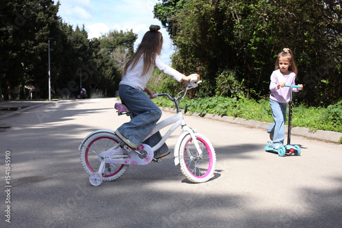 little cute girl riding a bicycle in green park, lifestyle people concept