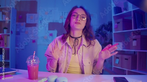 Work-Life Balance, Digital Lifestyle, Neon Mood. Young Woman in Creative Home Office Joins Business Video Call. Calm Focus and Comfort in a Modern Flexible Work Environment