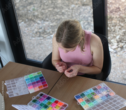 teenage girl making beads at home, lifestyle people concept